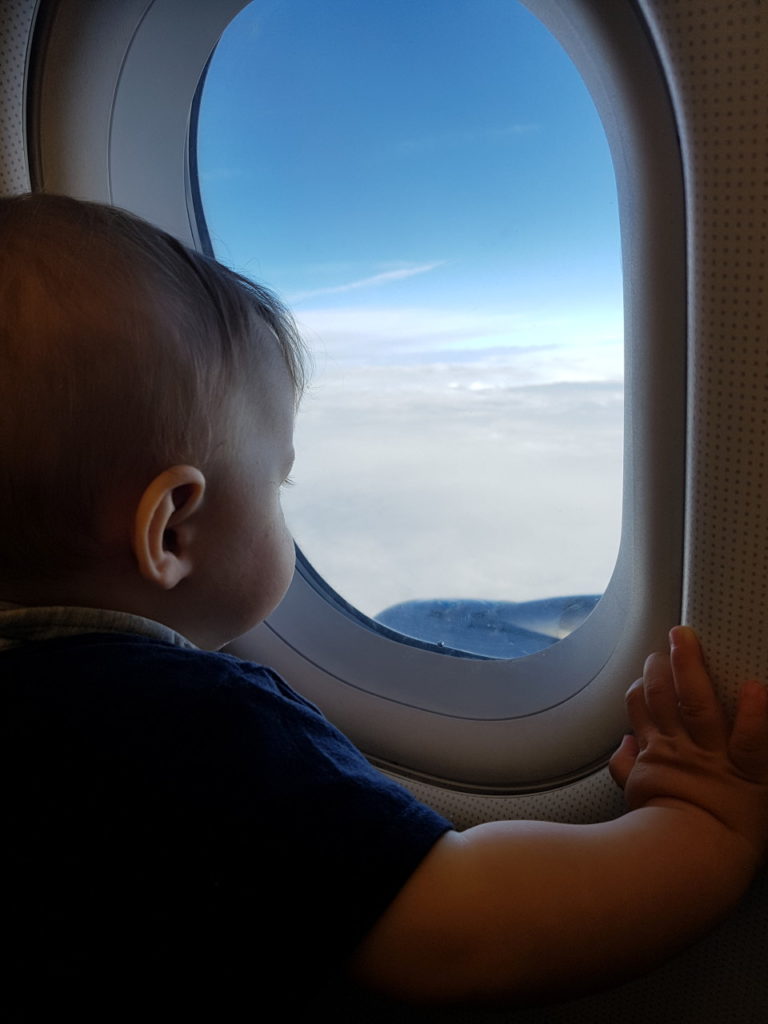 Baby guckt aus Flugzeug